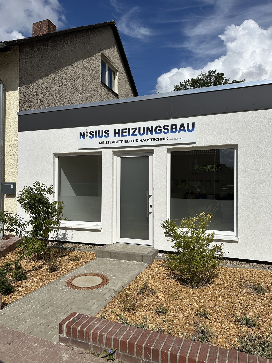 Fassadenschild Nisius Heizungsbau über dem Eingang