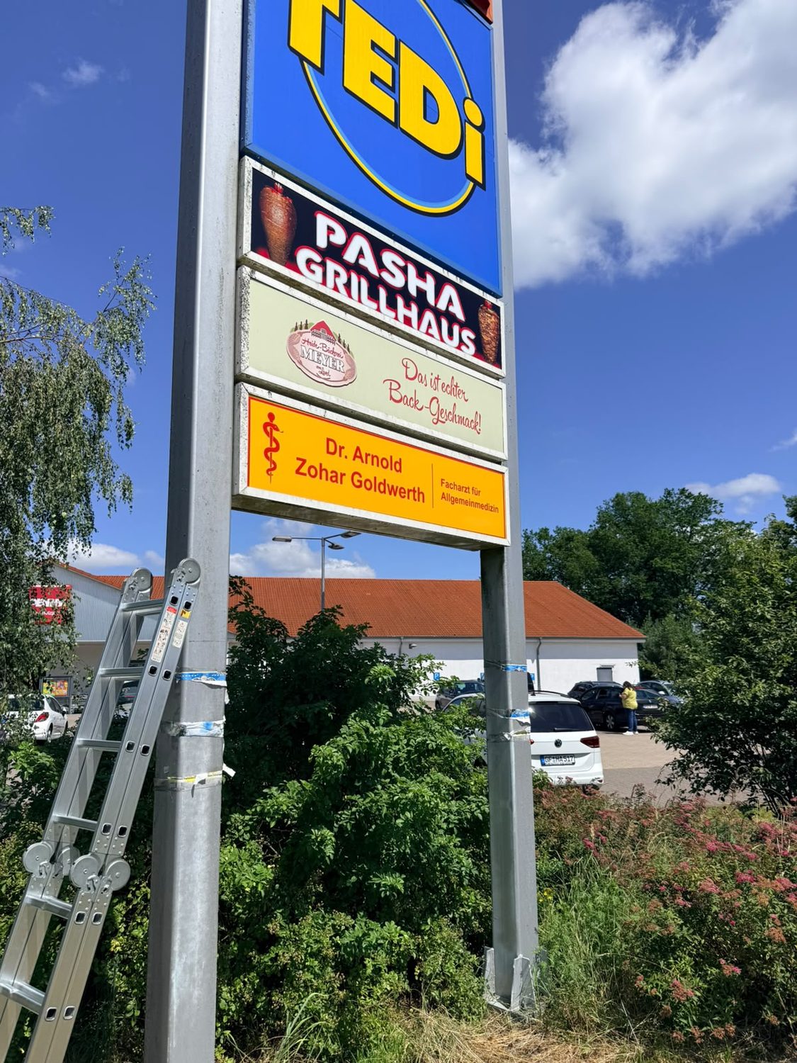 Pylon mit Mieterschildern: TEDi, Pasha Grillhaus, Bäckerei, Arztpraxis